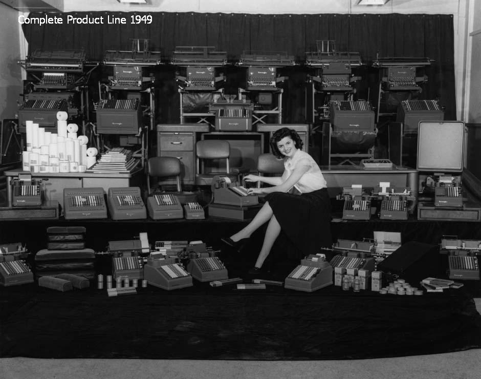 Burroughs Complete Product Line, 1949 Woman sitting in the middle of a variety of office equipment