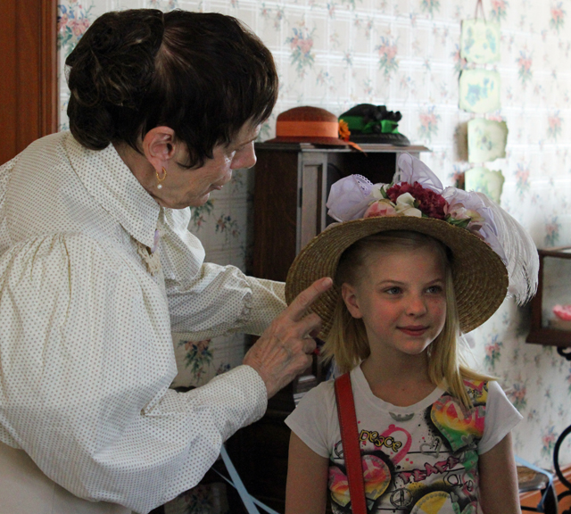 The presenter adjusts a visitor's hat The presenter adjusts a visitor's hat