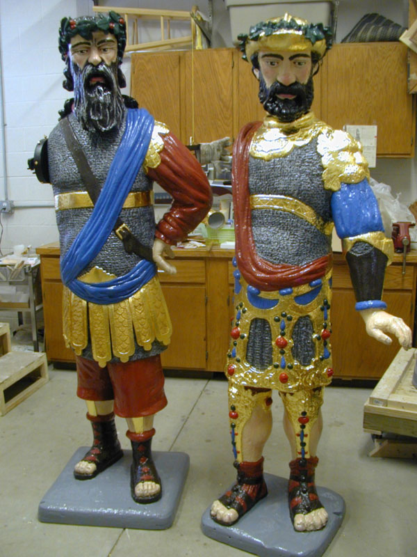 Two colorful sculptures of bearded men wearing elaborate costumes