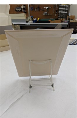 Back of covered and boarded comic book propped on plate stand Cardboard rectangle on stand