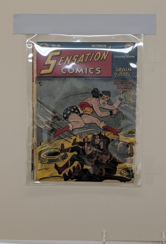 Mylar envelope being used to separate comic book from glass frame (to come) Comic book encased in plastic attached to mat