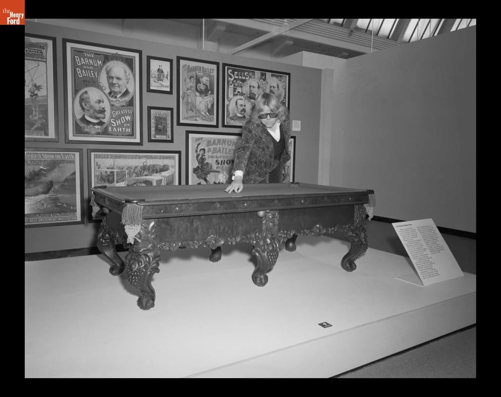 Paul Williams Visiting Henry Ford Museum, May 7, 1980 Man leans over miniature pool table in front of a wall filled with posters