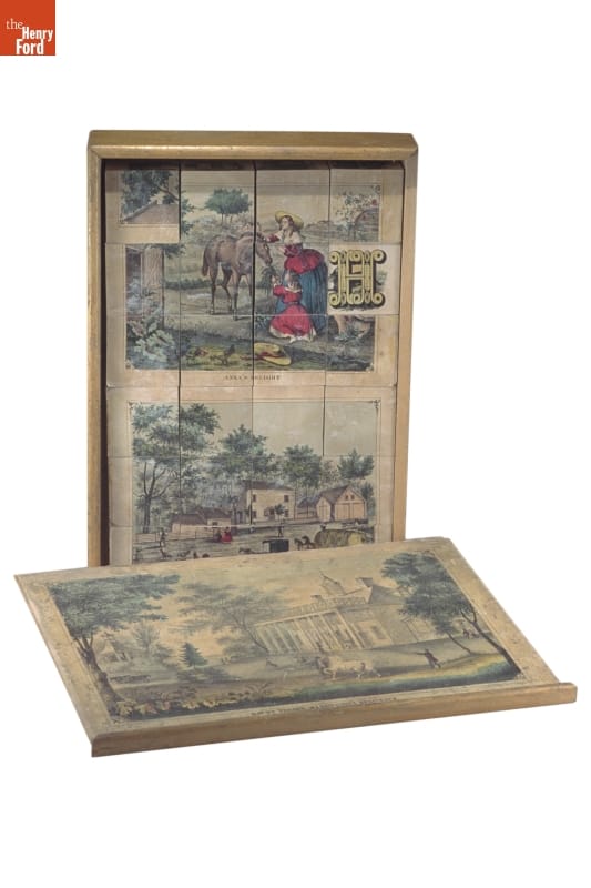 Picture Puzzle, 1858-1863 box, standing vertically with blocks with image on them in it; box lid lying in front with image on it