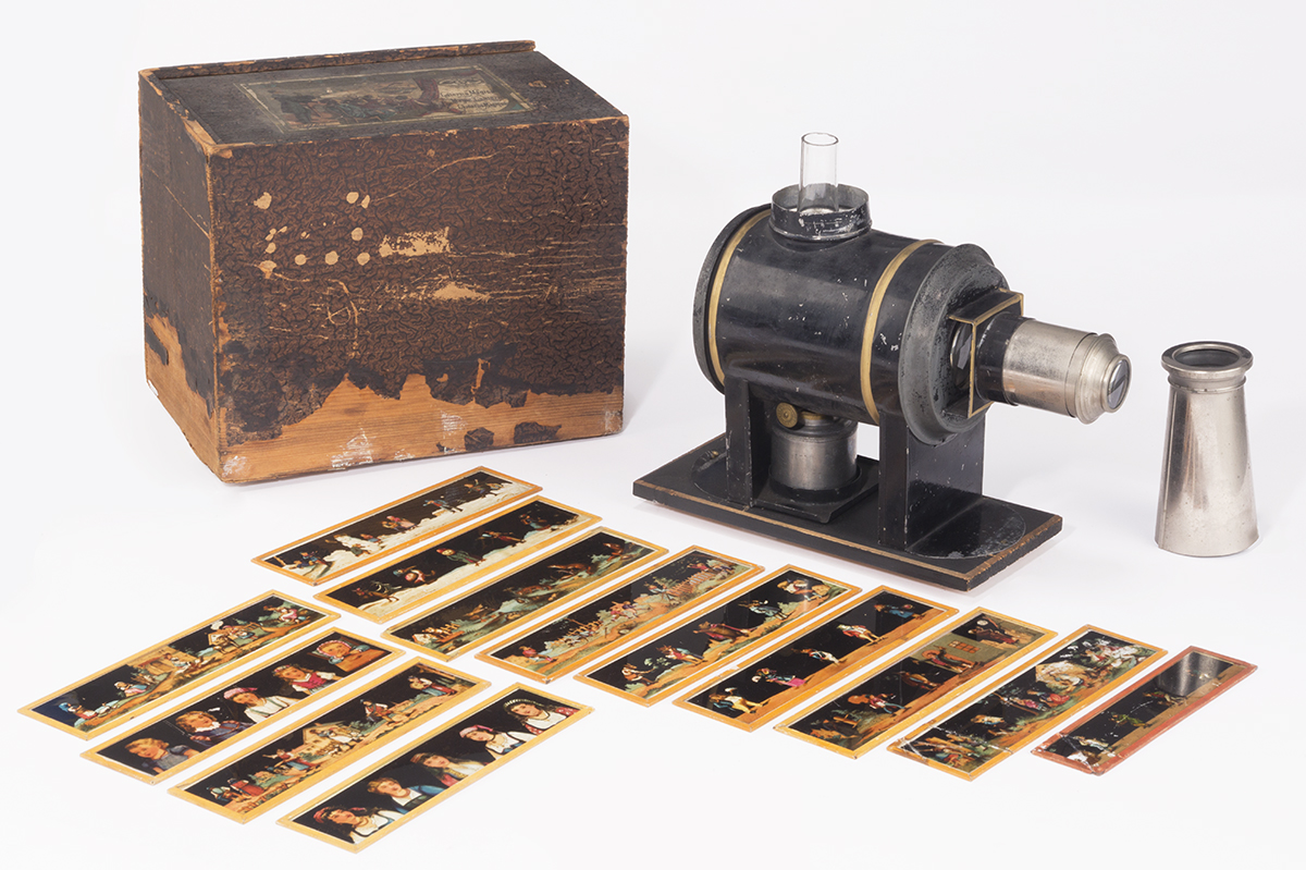 Wooden box, strips of translucent images, and small metal and glass machine