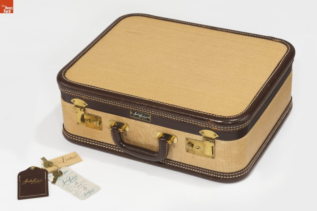 Orenstein Trunk Company Amelia Earhart Brand Luggage Overnight Case, 1943-1950 Camel-colored suitcase with brown trim and gold hardware; keys and a label sit nearby