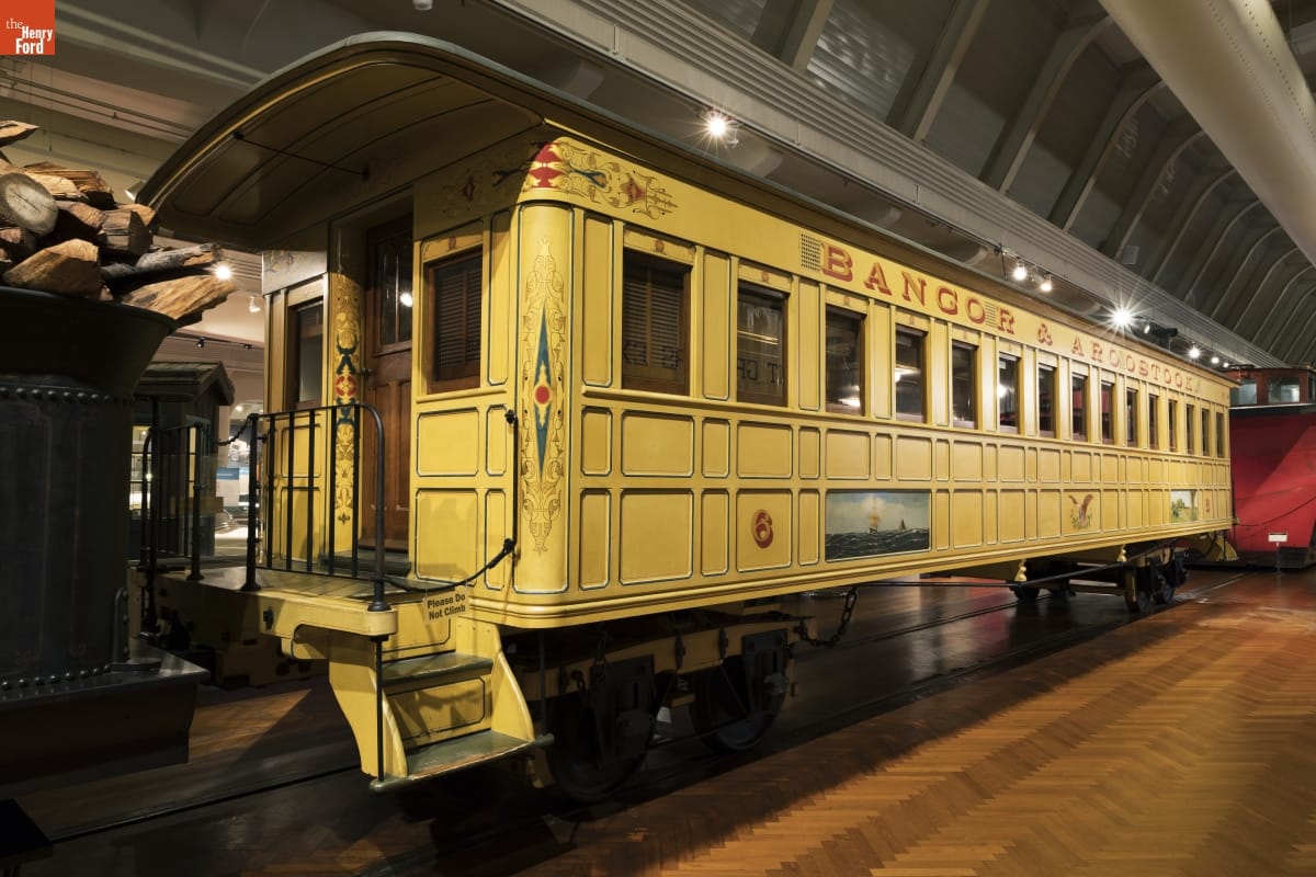 Bangor & Aroostook Railroad Passenger Coach Replica Yellow railcar with decorative elements inside large building