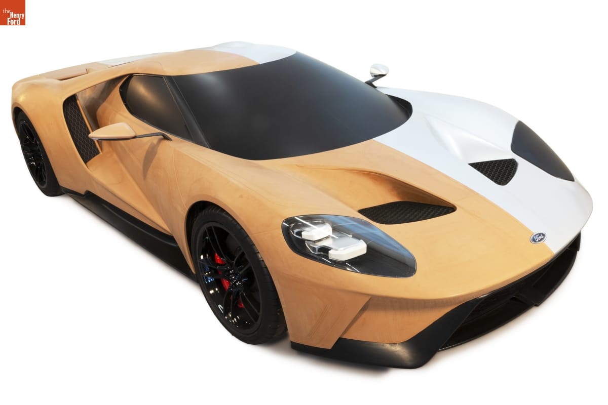 Car, half of which is orange clay-colored and half of which is white, with black windshield, wheels, and trim 