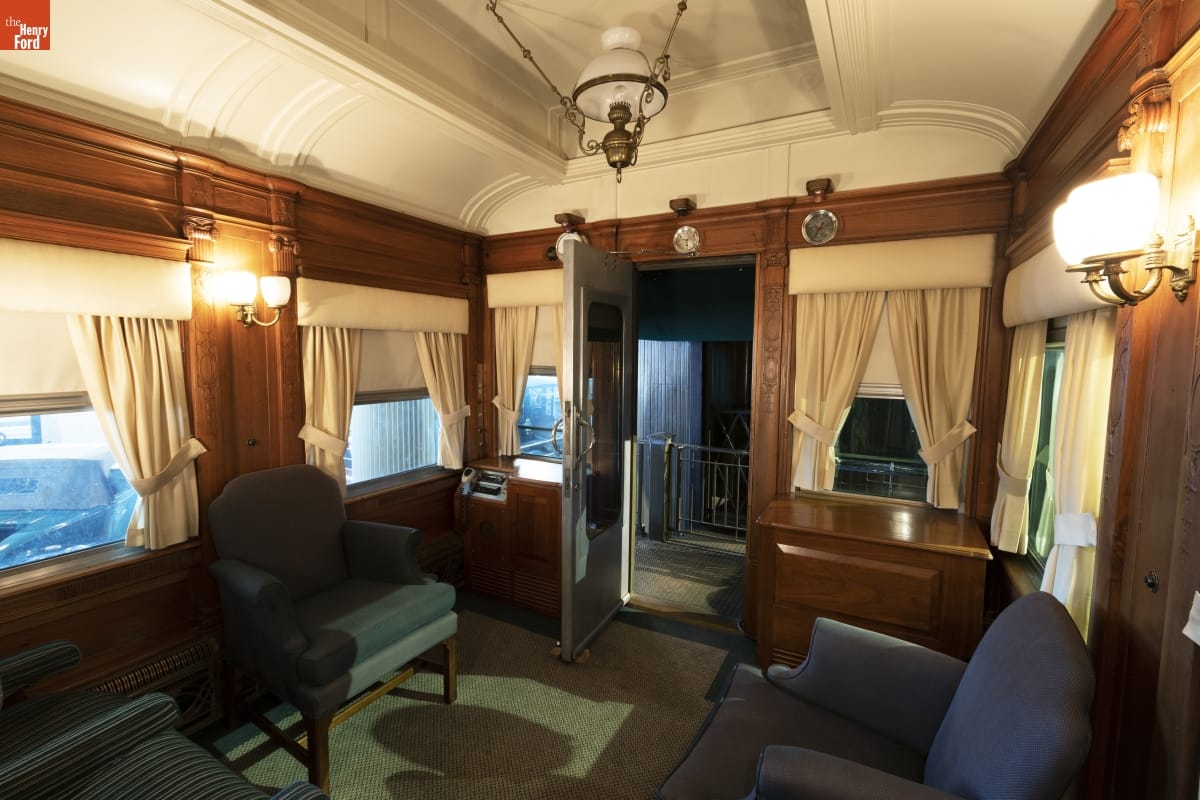 Interior of room with wooden paneling, blue upholstered seating, and an arched ceiling