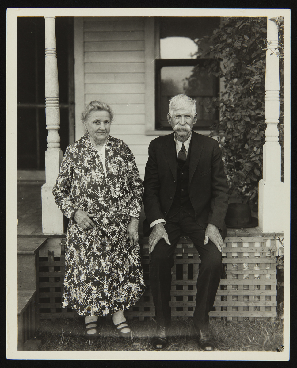 Woman and man sit on the edge of a porch