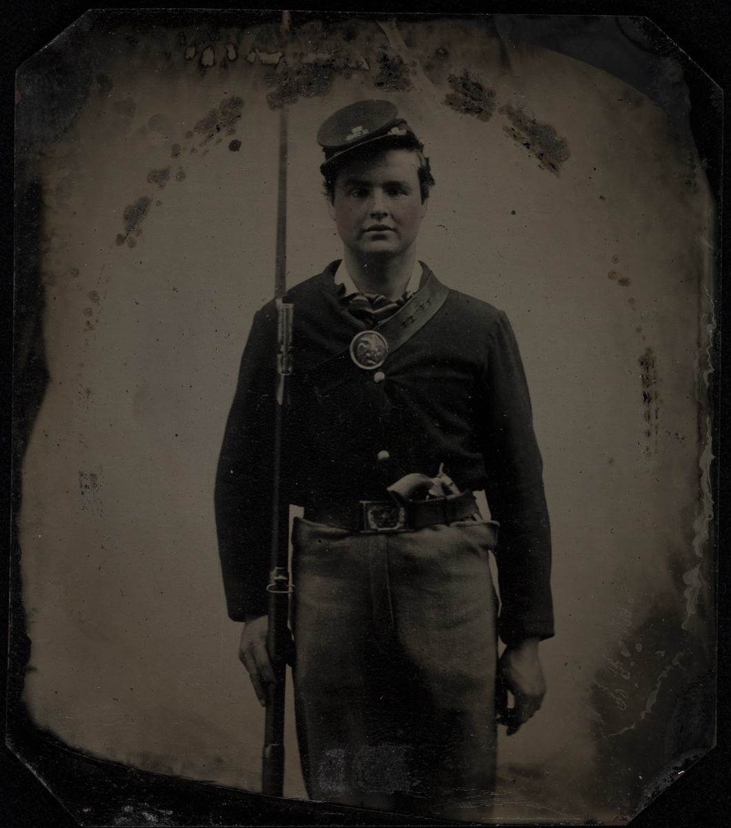Private Frank Stough with an 1842 Springfield Rifle, circa 1865 Man in uniform and cap holding rifle and standing at attention