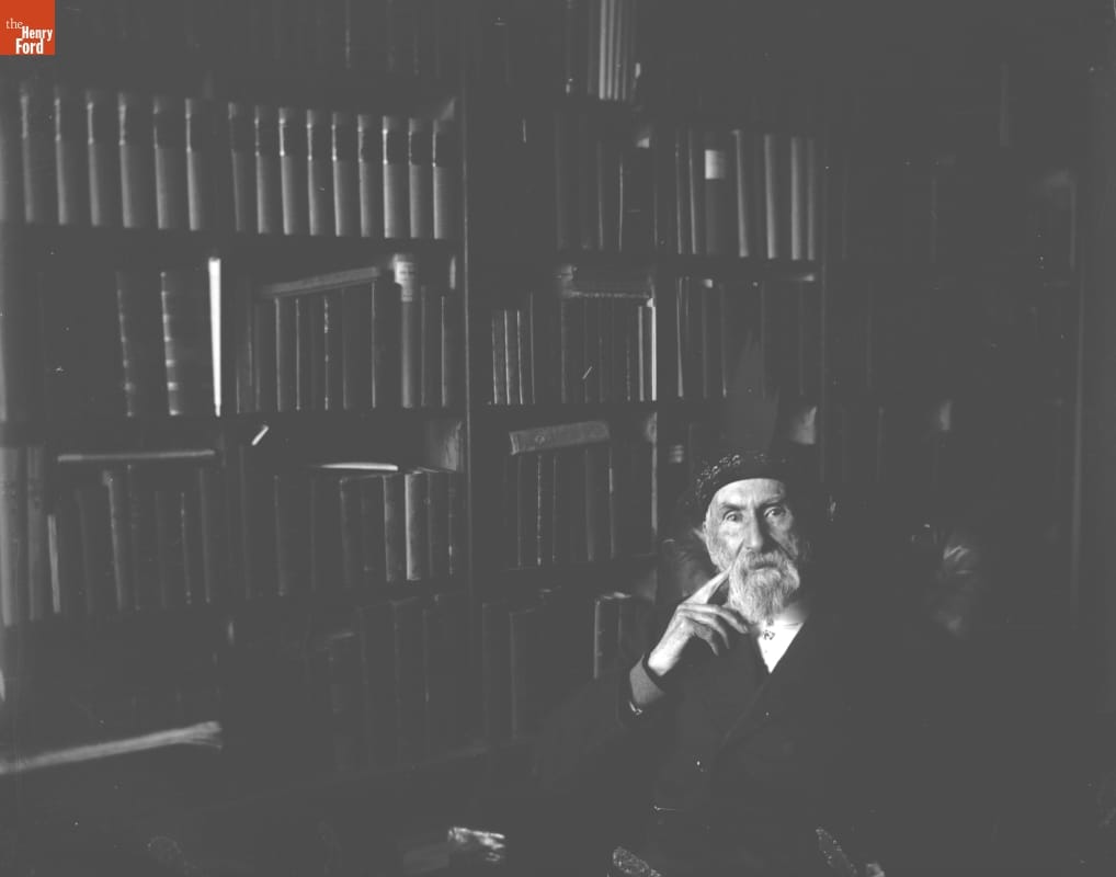Library (James A. H. Bell), 1890-1915 Man sitting in front of wall filled with books