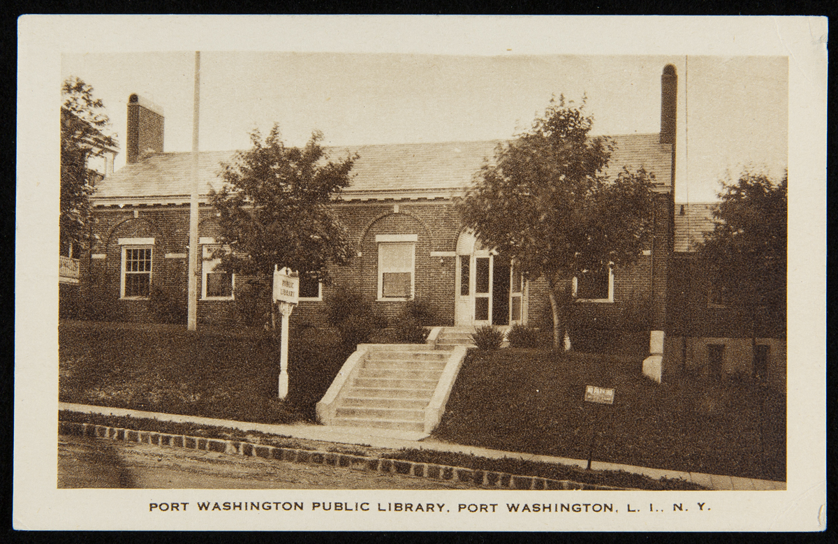 Brick building with sloping lawn and steps down to sidewalk in front; also contains text