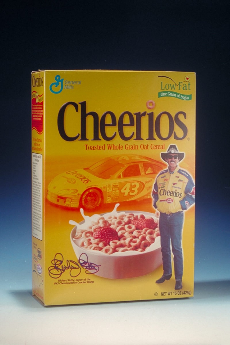 Cheerios Breakfast Cereal Featuring Richard Petty, 2001 Yellow cereal box with images of a race car, bowl of cereal and milk, and a standing man; also contains text