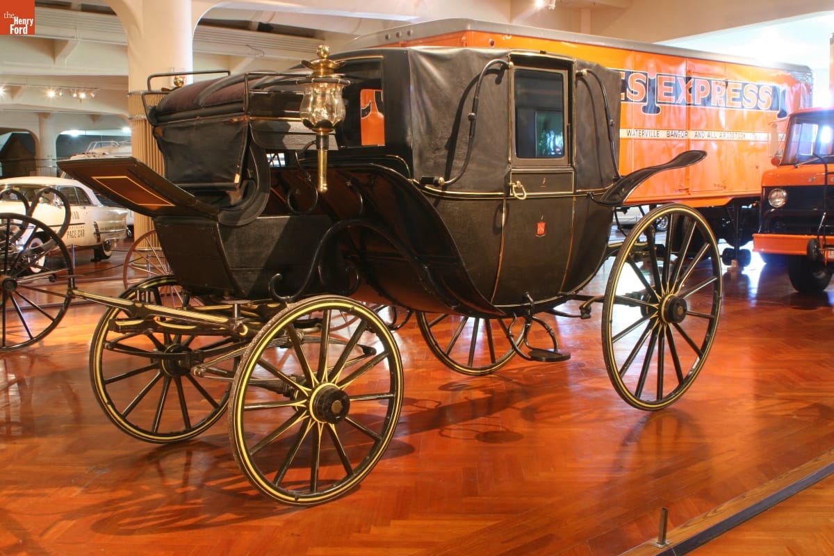 Landau, Made for Abram and Sarah Hewitt of New York, 1890 Black carriage with elevated coachman's seat in front; in room with other vehicles of various types