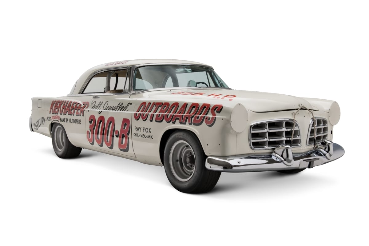 White car with large red and black text on side and hood